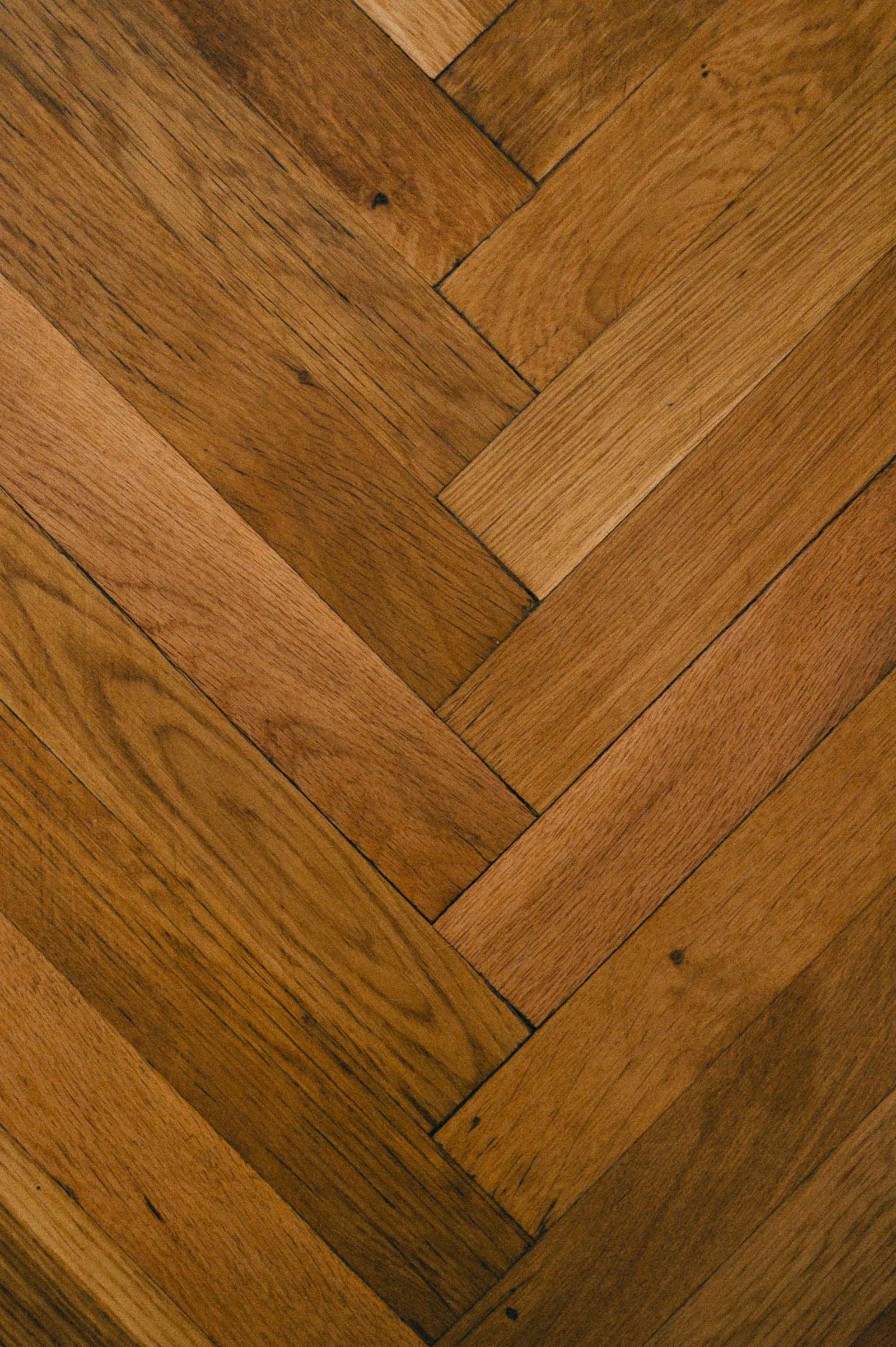 Herringbone-pattern paver patio viewed from above showing alternating angled V rows