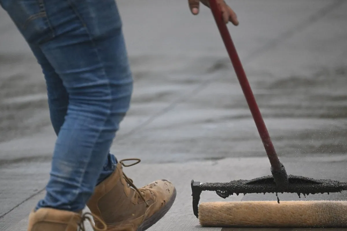 Applying sealant to a paver patio surface with a roller