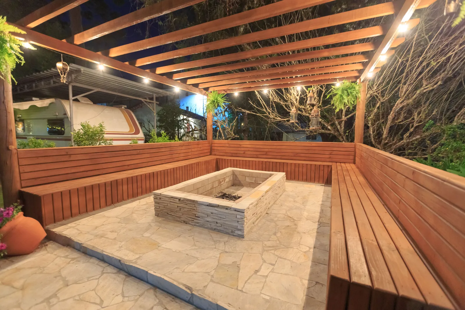 Paver patio with a stone fire pit centered in a circular seating layout surrounded by pavers